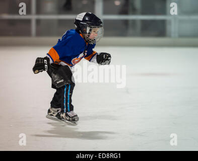 East Meadow, New York, USA. 31. Dezember 2014. Ein kleiner Junge, ein New York Islanders Eishockey Team Stil t-Shirt, Schlittschuhe vor die 5K Silvester Eve Strich, der Long Island Rat über Alkoholismus und Drogen Abhängigkeit (LICADD) am Twin RInks Ice Center Eisenhower Park auf Long Island zu unterstützen. Ein Skatin' Silvester Eve Veranstaltung begann Stunden früher und ein New Silvester-Party, offen für Läufer, Familie und Freunde weiter bis 02:30 Credit: Ann E Parry/Alamy Live News Stockfoto