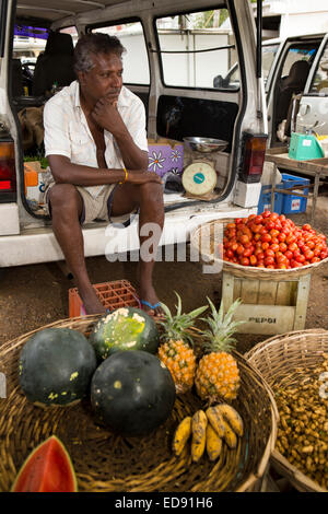 Mauritius, Tamarin, Markt, Mann verkaufen Gemüse saß hinter van Stockfoto