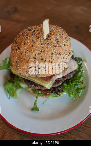 Australische Hamburger mit 'Lot' (Salat, Tomate, Zwiebel, Käse, Speck, Spiegelei und rote Beete) auf einem bestreute Brötchen serviert. Stockfoto