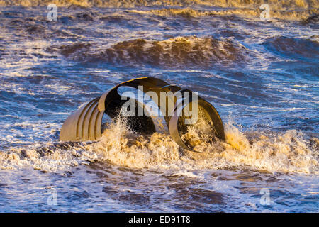 Mary's Shell eine runde Strandskulptur aus Blech von Stephen Broadbent Thornton-Cleveleys, Blackpool, Lancashire, 'Cleveleys mythological Coastline' Sonnenuntergang über der irischen Küste mit öffentlichen Kunstwerken von Shell Mythic Coast, Eine vier Meter hohe interaktive Golden Seashell am Vorland Mary's Shell, die Teil von drei Ergänzungen an der Strandpromenade mit Symbolen von The Sea Swallow ist. Stockfoto