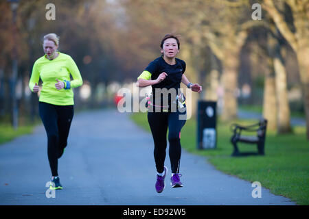 Zwei Frauen Läufer Teilnahme an der Aberystwyth 5K Park laufen, Plascrug Avenue, an einem Samstagmorgen im Dezember. Stockfoto