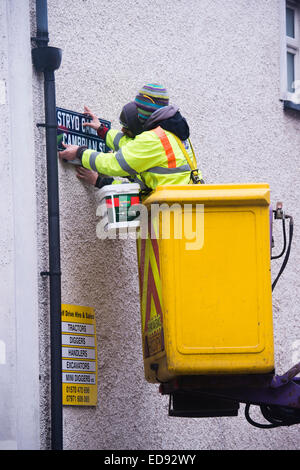 Zwei lokale Behörde (Ceredigion County Council) direkte Arbeitskräfte beschäftigten Arbeitnehmer in eine "Cherry-Picker" ersetzt die Zeichen auf der Cambrian Street, Aberystwyth, mit neuen Versionen mit "Erbe" Schrift, Wales UK Stockfoto