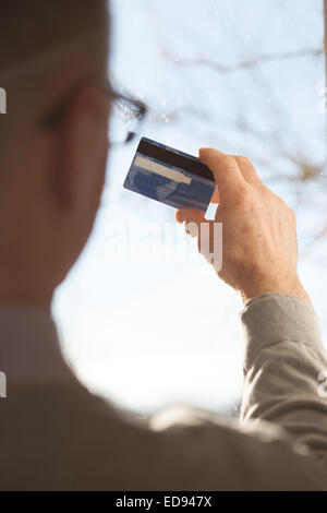 Ältere männliche Hände halten eine Plastikkarte Stockfoto