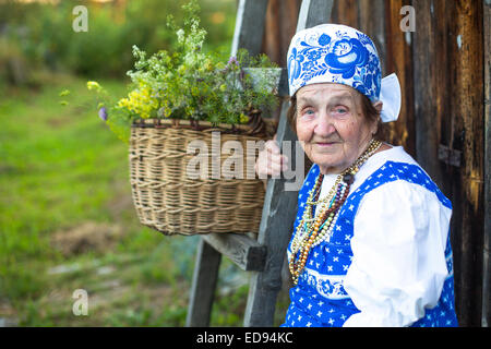 Großmutter im Dorf auf der Bank. Stockfoto