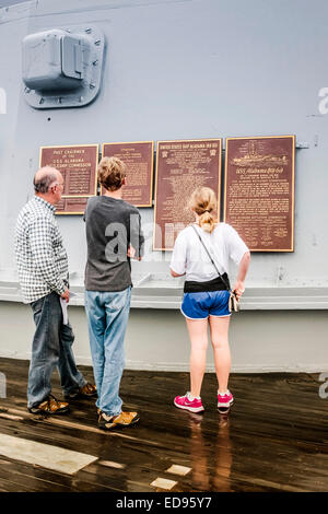 Ein Vater mit seinen Kindern lesen die Widmung Plaques auf einen Geschützturm des Schlachtschiffes USS Alabama befindet sich in der Gedenkstätte Par Stockfoto