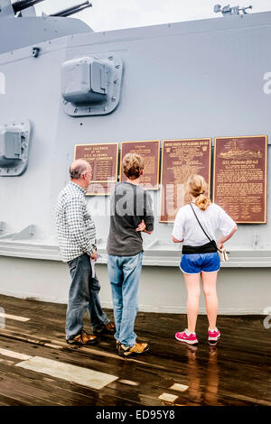 Ein Vater mit seinen Kindern lesen die Widmung Plaques auf einen Geschützturm des Schlachtschiffes USS Alabama befindet sich in der Gedenkstätte Par Stockfoto