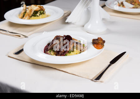 Scheiben Roastbeef garniert mit einer leckeren reichen Soße serviert auf einem Bett aus herzhaften Reis und Gemüse Stockfoto