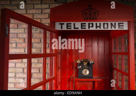 Detail der roten Fernsprechstelle mit alten altmodische Telefon innen und offenen Tür hautnah Stockfoto