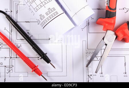 Rollen der Schaltpläne, Kabel multimeter und Metall Zange auf Konstruktionszeichnungen des Haus, elektrische Zeichnungen liegen Stockfoto