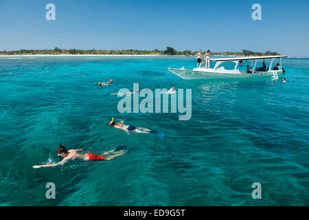 Touristenboot mit Schnorchler vor der Küste von Gili Air Insel in Indonesien. Stockfoto