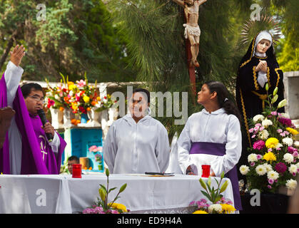Ein Priester Vorformen einen Dienst auf dem Friedhof in DAY OF THE DEAD - SAN MIGUEL DE ALLENDE, Mexiko Stockfoto