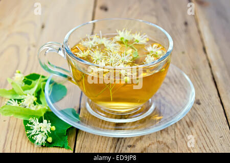 Kräutertee von Lindenblüten in Glasschale an Bord Stockfoto