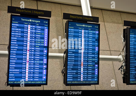 Bildschirme mit Abfahrtszeiten am Internationalen Flughafen Pearson YYZ Toronto, Ontario, Kanada. In französischer Sprache geschrieben. Stockfoto