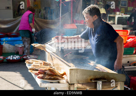 Mann, Braten von Fisch in Jagalchi Markt Busan, Republik Korea Stockfoto