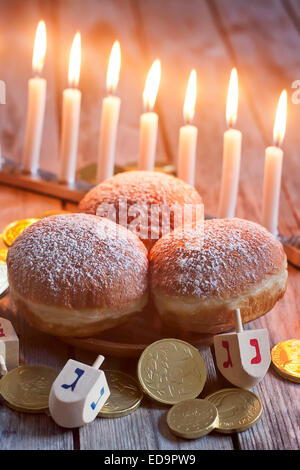 Jüdischer Feiertag Hannukah Symbole - Menora, Krapfen, Chockolate Münzen und Holz Dreidel. Stockfoto