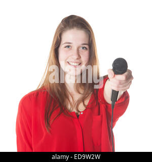 junge Brünette mit Mikrofon im Studio vor weißem Hintergrund Stockfoto