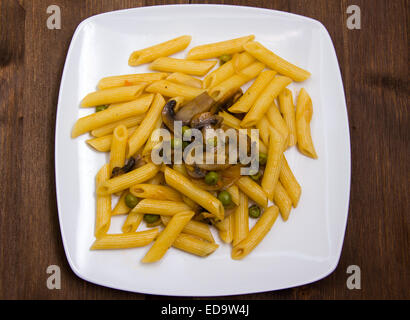 Pasta mit Pilzen und Erbsen auf Holztisch Draufsicht Stockfoto