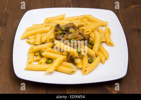 Pasta mit Pilzen und Erbsen auf Holztisch Stockfoto