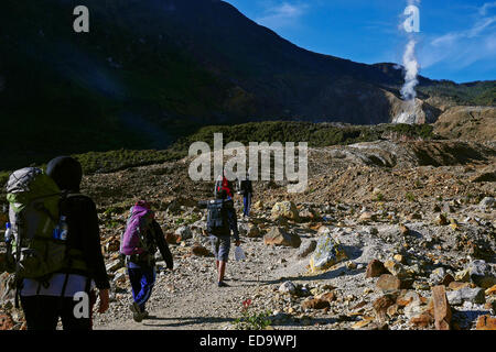 Bergsteiger wandern auf einem felsigen Pfad im Hintergrund des Kraters des Vulkans Mount Papandayan in Garut, West Java, Indonesien. Stockfoto