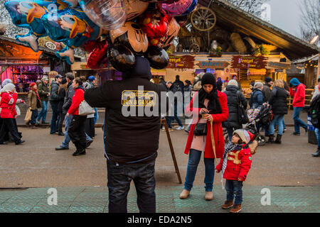 London, UK. 1. Januar 2015. Winter Wonderland im Hyde Park Contuinues, große Massen aus allen Segmenten der Londoner Gesellschaft - Familien und Erwachsene jeden Alters zu zeichnen scheinen die letzten Tropfen Weihnachtsstimmung durch Teilhabe an den Jahrmarkt Aktivitäten und Diashow sowie durch kalorienreiche Lebensmittel essen und trinken suchen. Lächeln ist ziemlich knapp außer von Kindern immer Ballons und Menschen auf der Achterbahn. Bildnachweis: Guy Bell/Alamy Live-Nachrichten Stockfoto