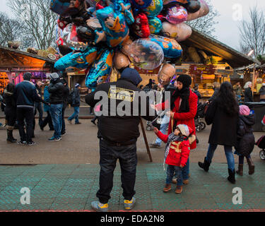 London, UK. 1. Januar 2015. Winter Wonderland im Hyde Park Contuinues, große Massen aus allen Segmenten der Londoner Gesellschaft - Familien und Erwachsene jeden Alters zu zeichnen scheinen die letzten Tropfen Weihnachtsstimmung durch Teilhabe an den Jahrmarkt Aktivitäten und Diashow sowie durch kalorienreiche Lebensmittel essen und trinken suchen. Lächeln ist ziemlich knapp außer von Kindern immer Ballons und Menschen auf der Achterbahn. Bildnachweis: Guy Bell/Alamy Live-Nachrichten Stockfoto