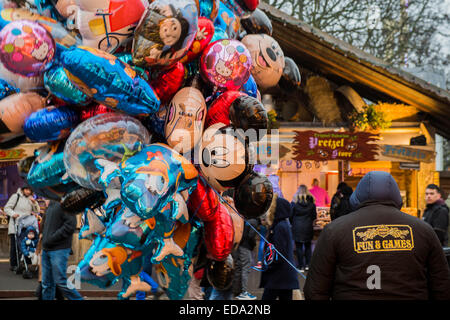 London, UK. 1. Januar 2015. Winter Wonderland im Hyde Park Contuinues, große Massen aus allen Segmenten der Londoner Gesellschaft - Familien und Erwachsene jeden Alters zu zeichnen scheinen die letzten Tropfen Weihnachtsstimmung durch Teilhabe an den Jahrmarkt Aktivitäten und Diashow sowie durch kalorienreiche Lebensmittel essen und trinken suchen. Lächeln ist ziemlich knapp außer von Kindern immer Ballons und Menschen auf der Achterbahn. Bildnachweis: Guy Bell/Alamy Live-Nachrichten Stockfoto