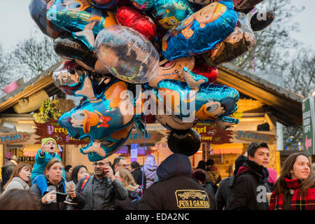 London, UK. 1. Januar 2015. Winter Wonderland im Hyde Park Contuinues, große Massen aus allen Segmenten der Londoner Gesellschaft - Familien und Erwachsene jeden Alters zu zeichnen scheinen die letzten Tropfen Weihnachtsstimmung durch Teilhabe an den Jahrmarkt Aktivitäten und Diashow sowie durch kalorienreiche Lebensmittel essen und trinken suchen. Lächeln ist ziemlich knapp außer von Kindern immer Ballons und Menschen auf der Achterbahn. Bildnachweis: Guy Bell/Alamy Live-Nachrichten Stockfoto