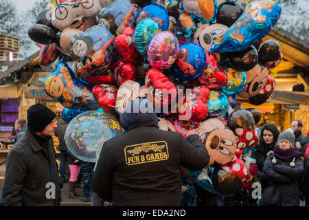 London, UK. 1. Januar 2015. Winter Wonderland im Hyde Park Contuinues, große Massen aus allen Segmenten der Londoner Gesellschaft - Familien und Erwachsene jeden Alters zu zeichnen scheinen die letzten Tropfen Weihnachtsstimmung durch Teilhabe an den Jahrmarkt Aktivitäten und Diashow sowie durch kalorienreiche Lebensmittel essen und trinken suchen. Lächeln ist ziemlich knapp außer von Kindern immer Ballons und Menschen auf der Achterbahn. Bildnachweis: Guy Bell/Alamy Live-Nachrichten Stockfoto