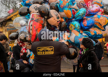 London, UK. 1. Januar 2015. Winter Wonderland im Hyde Park Contuinues, große Massen aus allen Segmenten der Londoner Gesellschaft - Familien und Erwachsene jeden Alters zu zeichnen scheinen die letzten Tropfen Weihnachtsstimmung durch Teilhabe an den Jahrmarkt Aktivitäten und Diashow sowie durch kalorienreiche Lebensmittel essen und trinken suchen. Lächeln ist ziemlich knapp außer von Kindern immer Ballons und Menschen auf der Achterbahn. Bildnachweis: Guy Bell/Alamy Live-Nachrichten Stockfoto