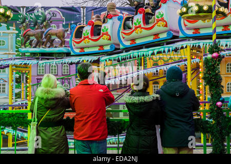 London, UK. 1. Januar 2015. Winter Wonderland im Hyde Park Contuinues, große Massen aus allen Segmenten der Londoner Gesellschaft - Familien und Erwachsene jeden Alters zu zeichnen scheinen die letzten Tropfen Weihnachtsstimmung durch Teilhabe an den Jahrmarkt Aktivitäten und Diashow sowie durch kalorienreiche Lebensmittel essen und trinken suchen. Lächeln ist ziemlich knapp außer von Kindern immer Ballons und Menschen auf der Achterbahn. Bildnachweis: Guy Bell/Alamy Live-Nachrichten Stockfoto