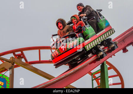 London, UK. 1. Januar 2015. Winter Wonderland im Hyde Park Contuinues, große Massen aus allen Segmenten der Londoner Gesellschaft - Familien und Erwachsene jeden Alters zu zeichnen scheinen die letzten Tropfen Weihnachtsstimmung durch Teilhabe an den Jahrmarkt Aktivitäten und Diashow sowie durch kalorienreiche Lebensmittel essen und trinken suchen. Lächeln ist ziemlich knapp außer von Kindern immer Ballons und Menschen auf der Achterbahn. Bildnachweis: Guy Bell/Alamy Live-Nachrichten Stockfoto