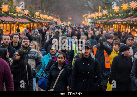 London, UK. 1. Januar 2015. Winter Wonderland im Hyde Park Contuinues, große Massen aus allen Segmenten der Londoner Gesellschaft - Familien und Erwachsene jeden Alters zu zeichnen scheinen die letzten Tropfen Weihnachtsstimmung durch Teilhabe an den Jahrmarkt Aktivitäten und Diashow sowie durch kalorienreiche Lebensmittel essen und trinken suchen. Lächeln ist ziemlich knapp außer von Kindern immer Ballons und Menschen auf der Achterbahn. Bildnachweis: Guy Bell/Alamy Live-Nachrichten Stockfoto