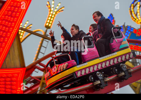 London, UK. 1. Januar 2015. Winter Wonderland im Hyde Park Contuinues, große Massen aus allen Segmenten der Londoner Gesellschaft - Familien und Erwachsene jeden Alters zu zeichnen scheinen die letzten Tropfen Weihnachtsstimmung durch Teilhabe an den Jahrmarkt Aktivitäten und Diashow sowie durch kalorienreiche Lebensmittel essen und trinken suchen. Lächeln ist ziemlich knapp außer von Kindern immer Ballons und Menschen auf der Achterbahn. Bildnachweis: Guy Bell/Alamy Live-Nachrichten Stockfoto