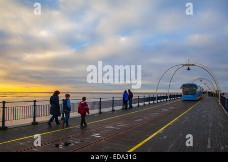 Southport, Merseyside, England 3. Januar 2014.   Großbritannien Wetter.  Clearing-Himmel an der Nordwestküste als Wochenendausflügler hinunter den Jahrgang Promenade, aber wieder hergestellt. Grad II aufgeführten Southport Pier. Es ist der älteste eiserne Pfeiler im Land, seit über 150 Jahren am Meer Stand.  Bildnachweis: Mar Photographics/Alamy Live-Nachrichten Stockfoto