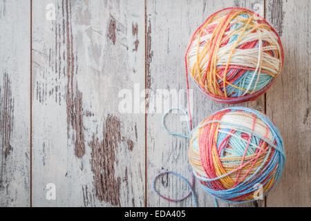 Bunte Kugeln aus Garn zum stricken auf weißer Holztisch Stockfoto