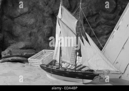 Marine Concept - süße Boot Miniatur auf Sand in monochromen Stil Stockfoto