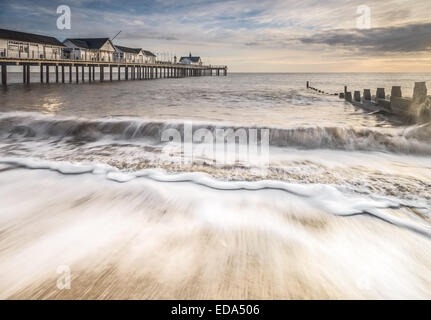 Goldenes Licht auf Southwold Peir, zeigen die Wellen brechen sich am Strand vor dem Hotel. Stockfoto