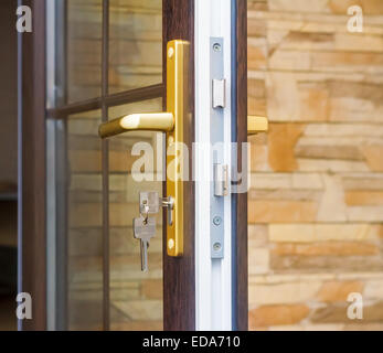 Das Fragment Eingang verglaste Tür mit Schloss mit Griff und Schlüssel. Stockfoto