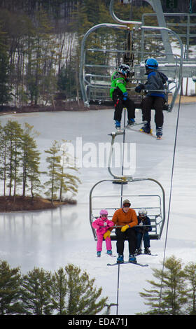 Skifahrer und Snowboarder steigen an die Spitze der Madison, New Hampshire König Kiefer Skipiste über einen Sessellift. Stockfoto