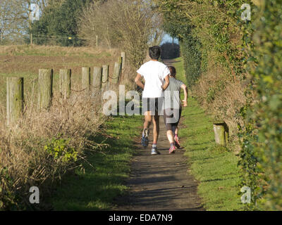 Asiatischer Mann und Caucasain Frau, die entlang einer öffentlichen Maultierweg, Cofton Hackett, Worcestershire, England, Vereinigtes Königreich, im Winter Stockfoto