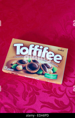 Schachtel Toffifee Süßwaren auf einem roten Hintergrund, UK Stockfoto