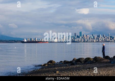 Frau auf der Suche über English Bay mit der Innenstadt von Vancouver im Hintergrund Stockfoto