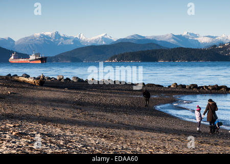 Zwei Frachtschiffen warten in English Bay in Vancouver mit dem Küstengebirge im Hintergrund Stockfoto