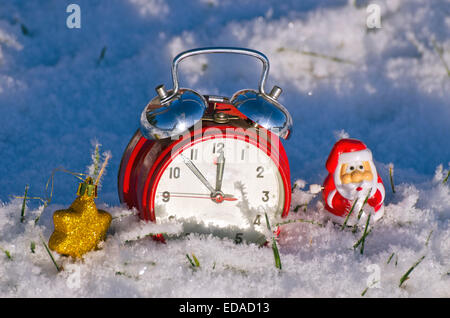 Uhr Neujahr und Weihnachten Weihnachtsmann Spielzeug auf frischen Winterschnee Stockfoto