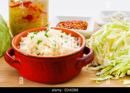 Hausgemachte Sauerkraut Sauerkraut mit gehackte Kraut, Peperoni und Gewürzen gemacht, auf einem Holzbrett Stockfoto