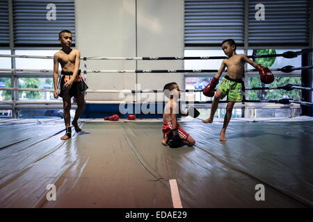 Bangkok, Thailand. 7. November 2014. Kinder trainieren Sie an einem Boxsäcke und Holm in einem Schulungsraum Boxen befindet sich in einem Slum von Bangkok. Jeden Abend, Kinder von Bangkok kommt zu üben Muay-Thai-Boxen in einem Slum der Hauptstadt, genügend Erfahrung zu bekommen, bevor die "echte" in einer Arena, umgeben von Tausenden von Menschen zu kämpfen, sie starten, sobald sie (ca. 4-5 Jahre alt), mit der Hoffnung, ein berühmter Boxer können und raus aus dem Armenviertel wo sie leben. © Guillaume Payen/ZUMA Wire/ZUMAPRESS.com/Alamy Live-Nachrichten Stockfoto