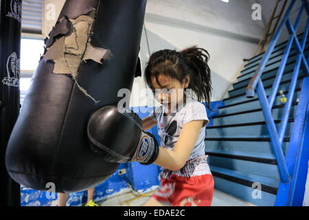 Bangkok, Thailand. 7. November 2014. Kinder trainieren Sie an einem Boxsäcke und Holm in einem Schulungsraum Boxen befindet sich in einem Slum von Bangkok. Jeden Abend, Kinder von Bangkok kommt zu üben Muay-Thai-Boxen in einem Slum der Hauptstadt, genügend Erfahrung zu bekommen, bevor die "echte" in einer Arena, umgeben von Tausenden von Menschen zu kämpfen, sie starten, sobald sie (ca. 4-5 Jahre alt), mit der Hoffnung, ein berühmter Boxer können und raus aus dem Armenviertel wo sie leben. © Guillaume Payen/ZUMA Wire/ZUMAPRESS.com/Alamy Live-Nachrichten Stockfoto