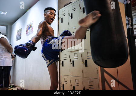 Bangkok, Thailand. 7. November 2014. Kinder trainieren Sie an einem Boxsäcke und Holm in einem Schulungsraum Boxen befindet sich in einem Slum von Bangkok. Jeden Abend, Kinder von Bangkok kommt zu üben Muay-Thai-Boxen in einem Slum der Hauptstadt, genügend Erfahrung zu bekommen, bevor die "echte" in einer Arena, umgeben von Tausenden von Menschen zu kämpfen, sie starten, sobald sie (ca. 4-5 Jahre alt), mit der Hoffnung, ein berühmter Boxer können und raus aus dem Armenviertel wo sie leben. © Guillaume Payen/ZUMA Wire/ZUMAPRESS.com/Alamy Live-Nachrichten Stockfoto