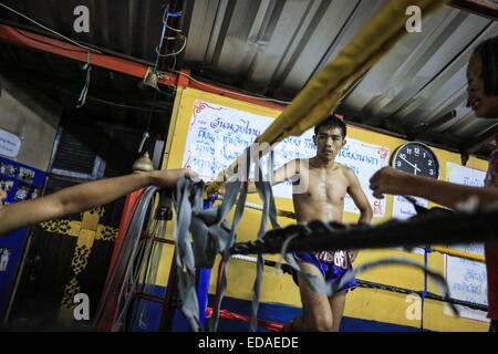 Bangkok, Thailand. 7. November 2014. Kinder trainieren Sie an einem Boxsäcke und Holm in einem Schulungsraum Boxen befindet sich in einem Slum von Bangkok. Jeden Abend, Kinder von Bangkok kommt zu üben Muay-Thai-Boxen in einem Slum der Hauptstadt, genügend Erfahrung zu bekommen, bevor die "echte" in einer Arena, umgeben von Tausenden von Menschen zu kämpfen, sie starten, sobald sie (ca. 4-5 Jahre alt), mit der Hoffnung, ein berühmter Boxer können und raus aus dem Armenviertel wo sie leben. © Guillaume Payen/ZUMA Wire/ZUMAPRESS.com/Alamy Live-Nachrichten Stockfoto