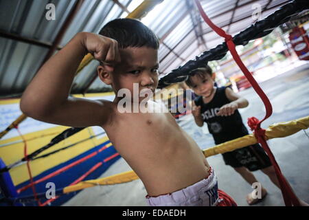 Bangkok, Thailand. 7. November 2014. Kinder trainieren Sie an einem Boxsäcke und Holm in einem Schulungsraum Boxen befindet sich in einem Slum von Bangkok. Jeden Abend, Kinder von Bangkok kommt zu üben Muay-Thai-Boxen in einem Slum der Hauptstadt, genügend Erfahrung zu bekommen, bevor die "echte" in einer Arena, umgeben von Tausenden von Menschen zu kämpfen, sie starten, sobald sie (ca. 4-5 Jahre alt), mit der Hoffnung, ein berühmter Boxer können und raus aus dem Armenviertel wo sie leben. © Guillaume Payen/ZUMA Wire/ZUMAPRESS.com/Alamy Live-Nachrichten Stockfoto